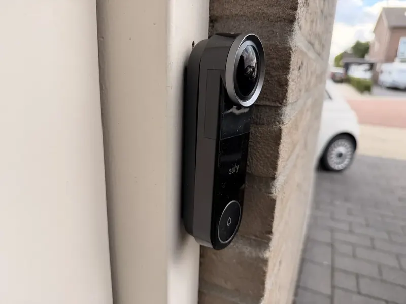 Eufy Video Doorbell S4 schuin van opzij op de montageplaat, met de straat op de achtergrond
